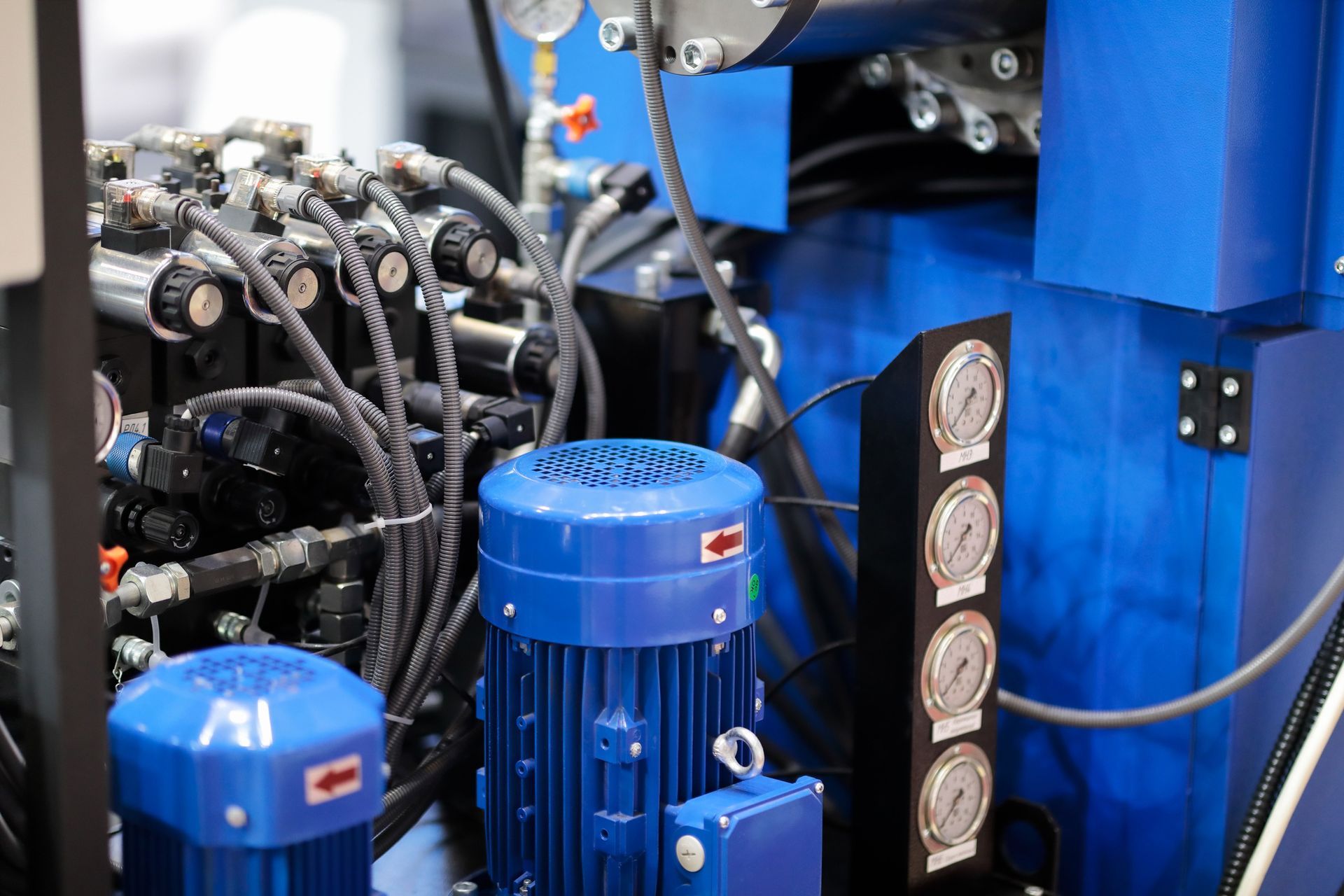 Blue industrial machinery with motors, gauges, and pipes.