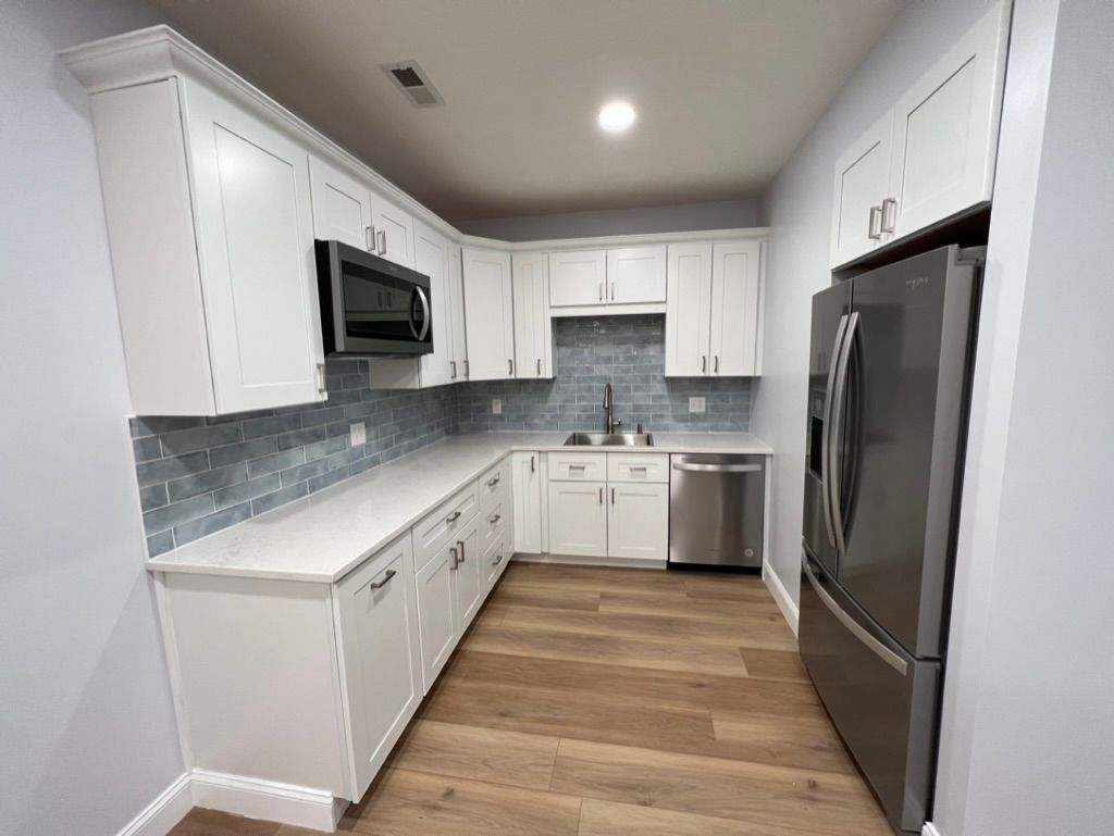 A kitchen with white cabinets and stainless steel appliances.