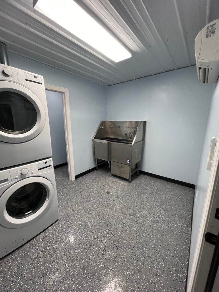 A laundry room with a washer and dryer and a sink.