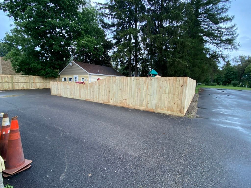 A wooden fence is sitting in the middle of a parking lot.