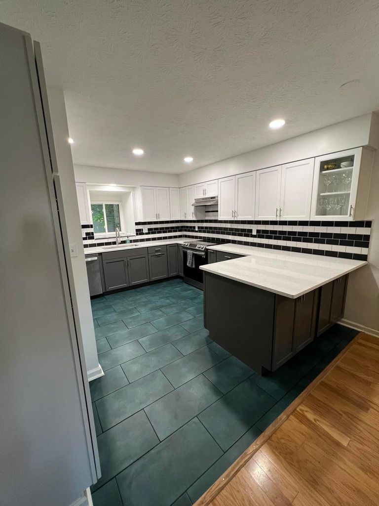 A kitchen with white cabinets and a large island in the middle.