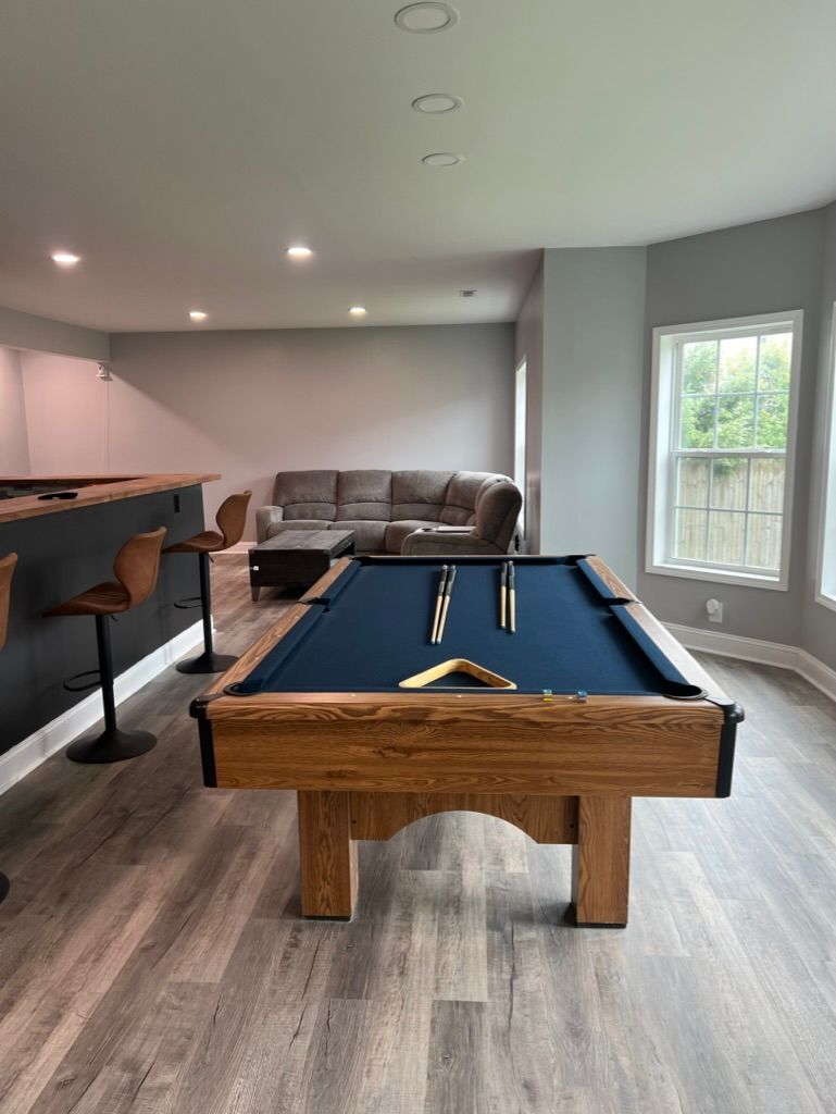 There is a pool table in the middle of the room.