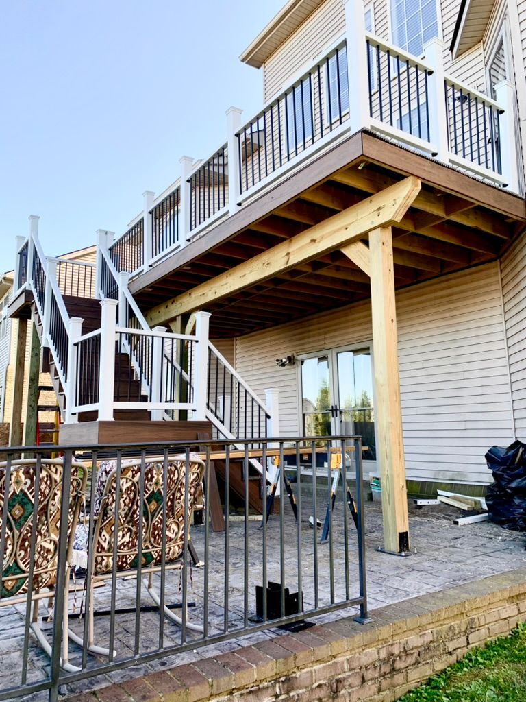 A large wooden deck is being built on the side of a house.