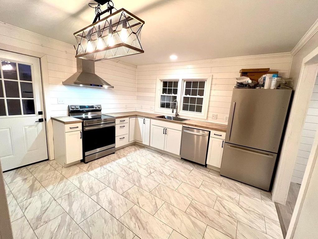 A kitchen with stainless steel appliances and white cabinets.