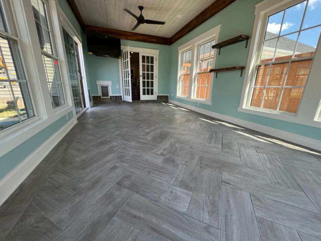 A large room with a lot of windows and a ceiling fan.