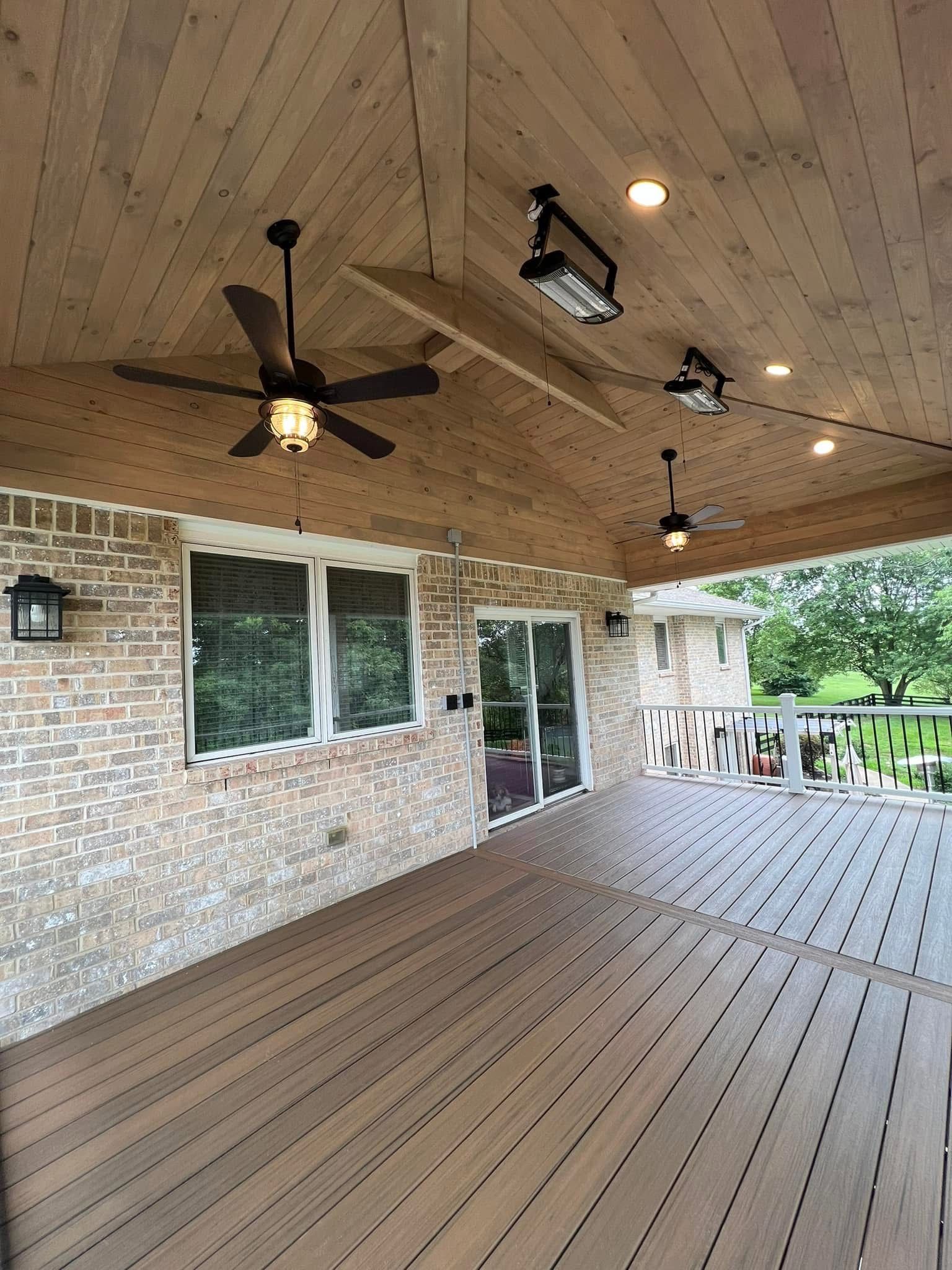 There is a ceiling fan on the deck of a house.