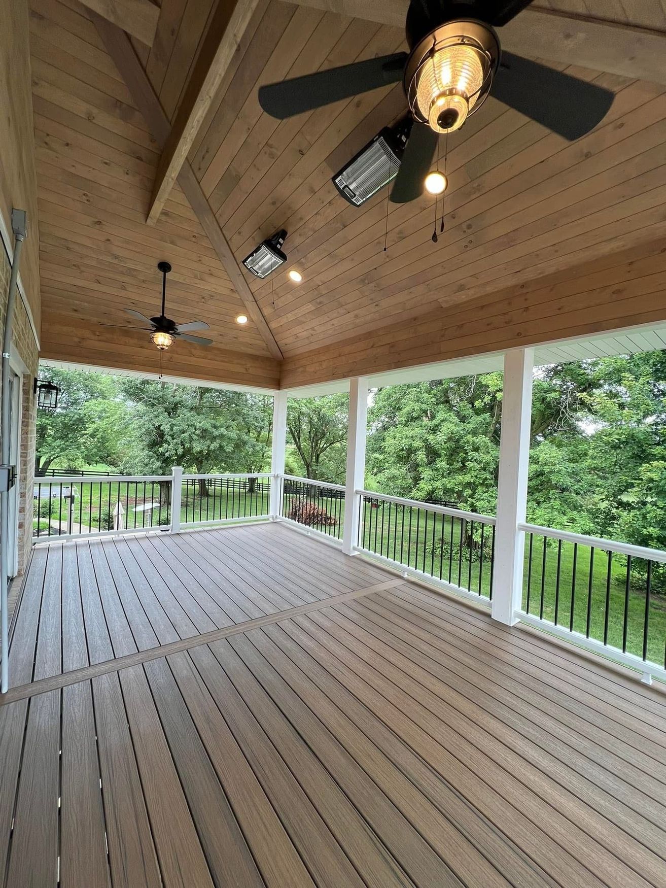 There is a ceiling fan on the porch of a house.