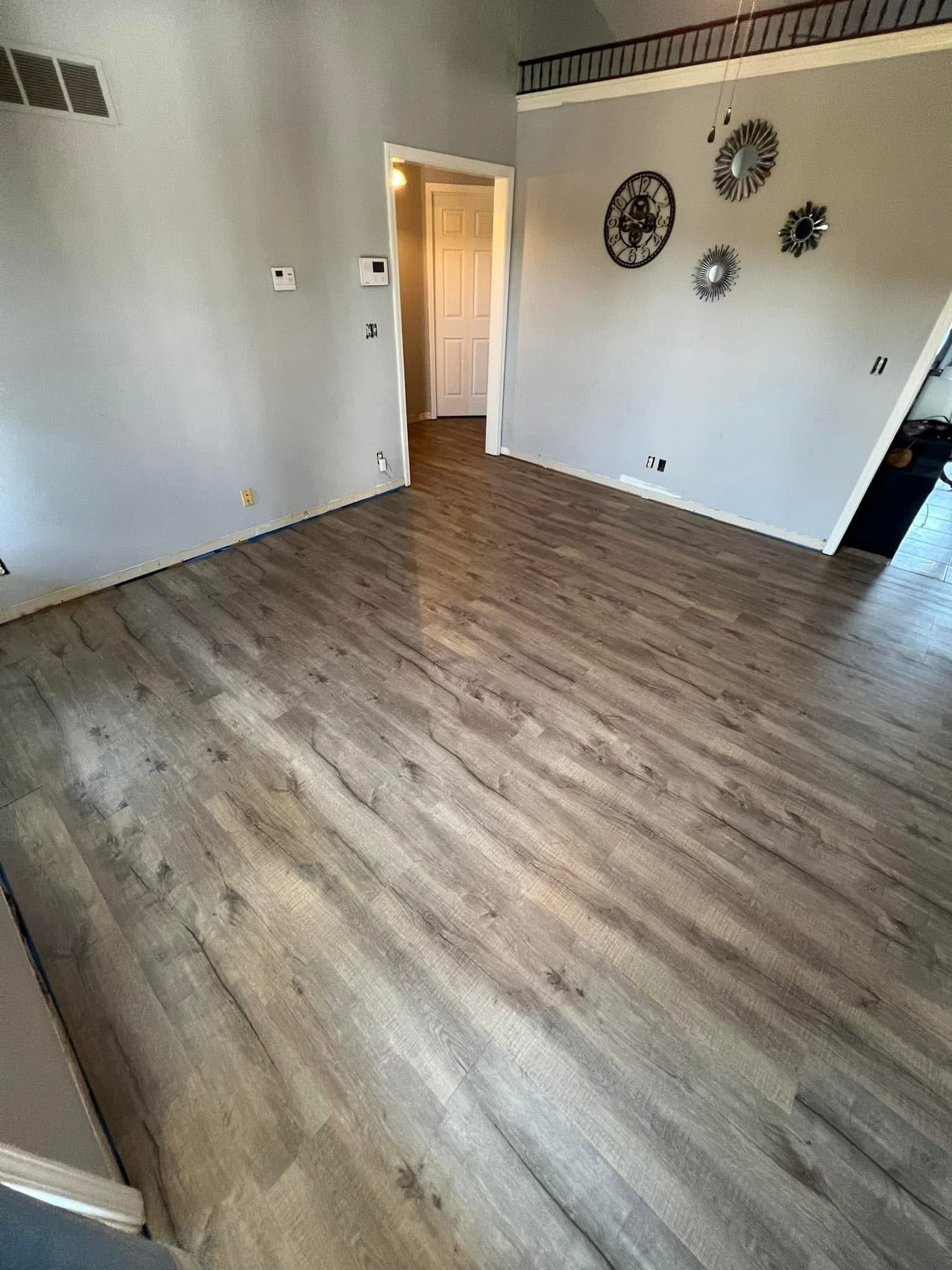 A living room with hardwood floors and a clock on the wall.