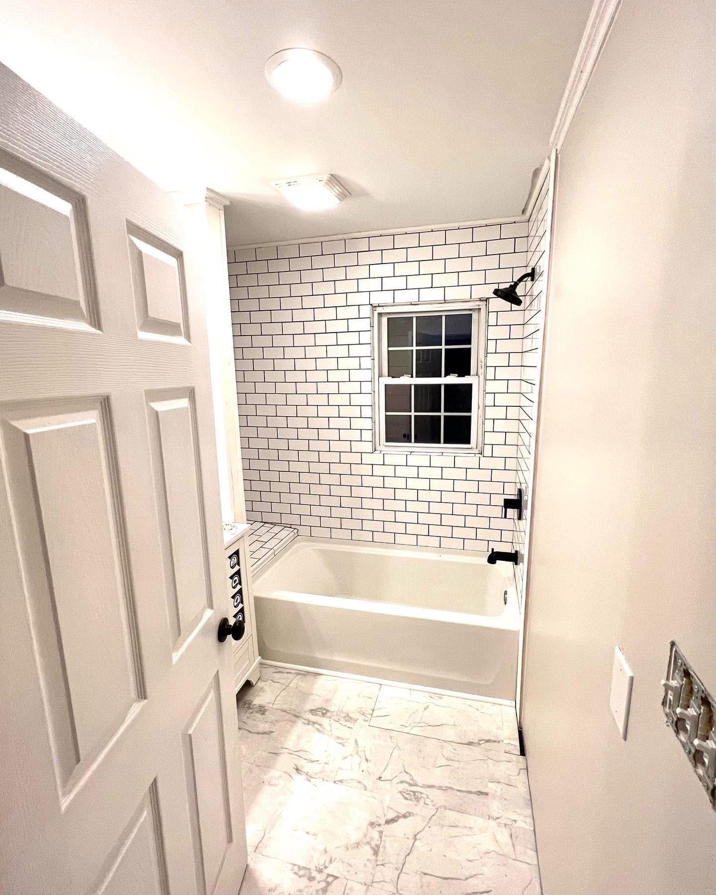 A bathroom with a bathtub and a window