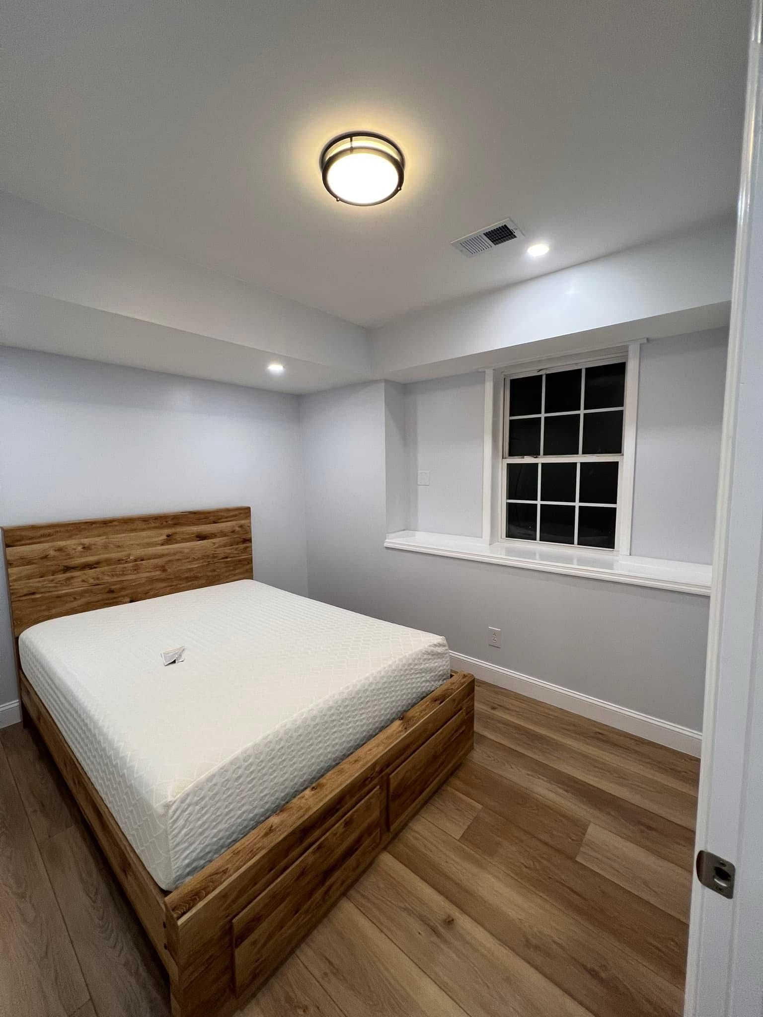 A bedroom with a wooden bed and a window.