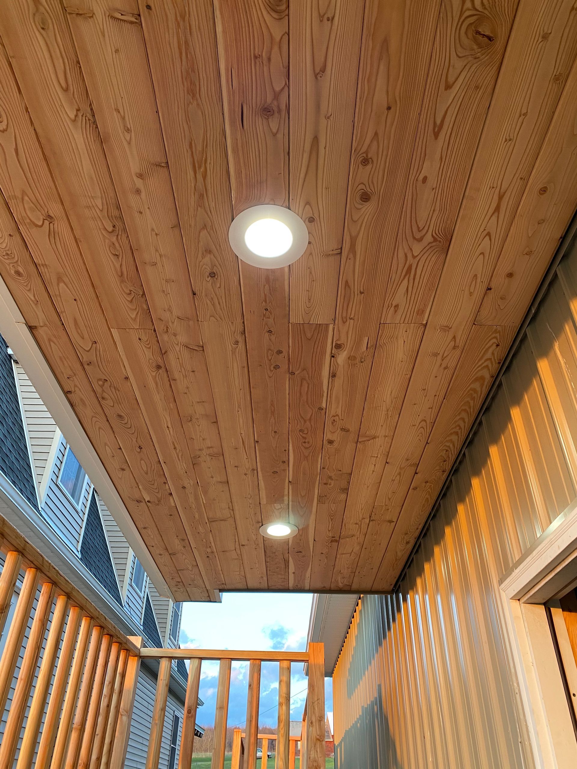 A balcony with a wooden ceiling and lights on it.