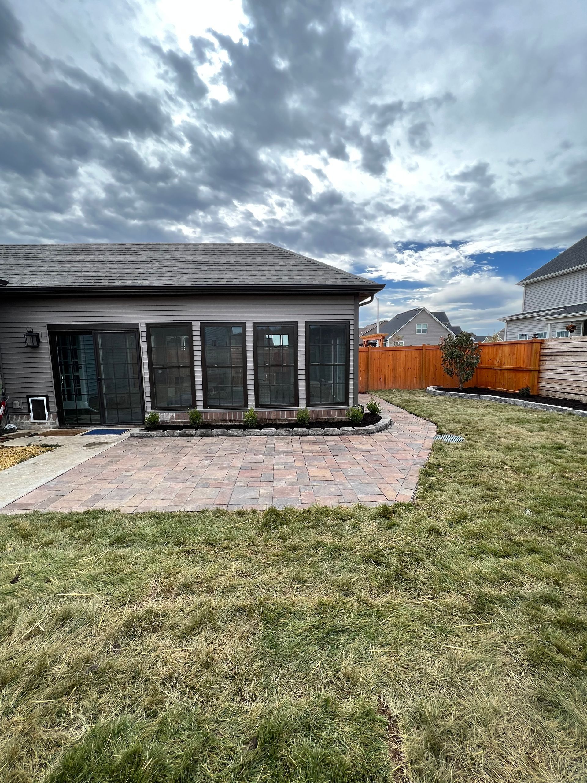 A house with a lot of windows and a large lawn in front of it.