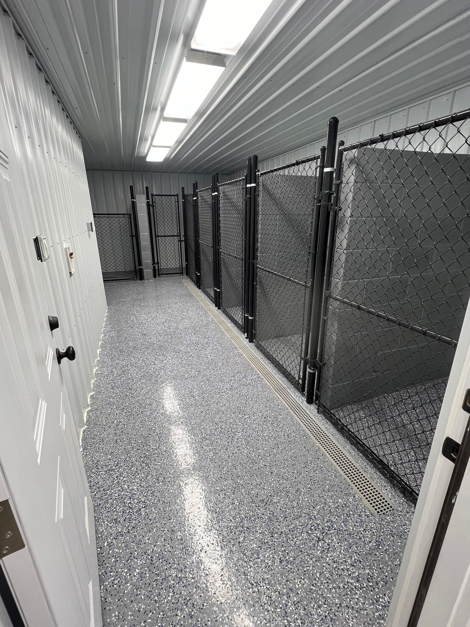 A long hallway with a chain link fence and lockers.