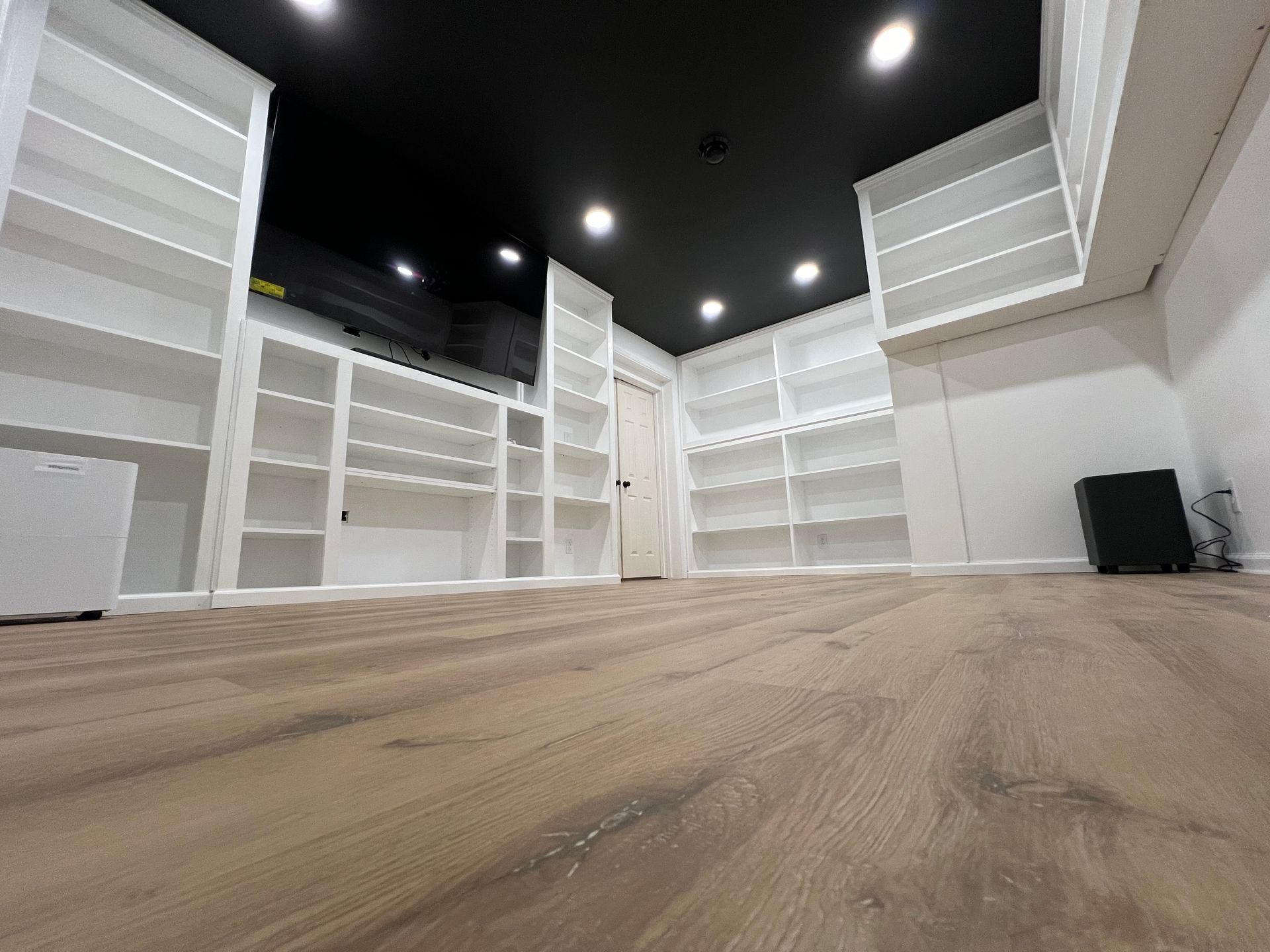 A large room with lots of shelves and a wooden floor.