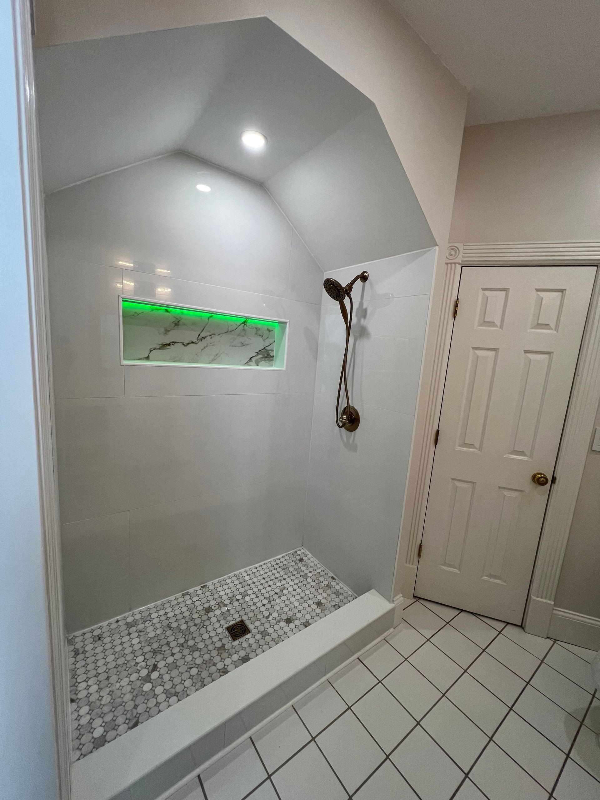 A bathroom with a walk in shower and a door.