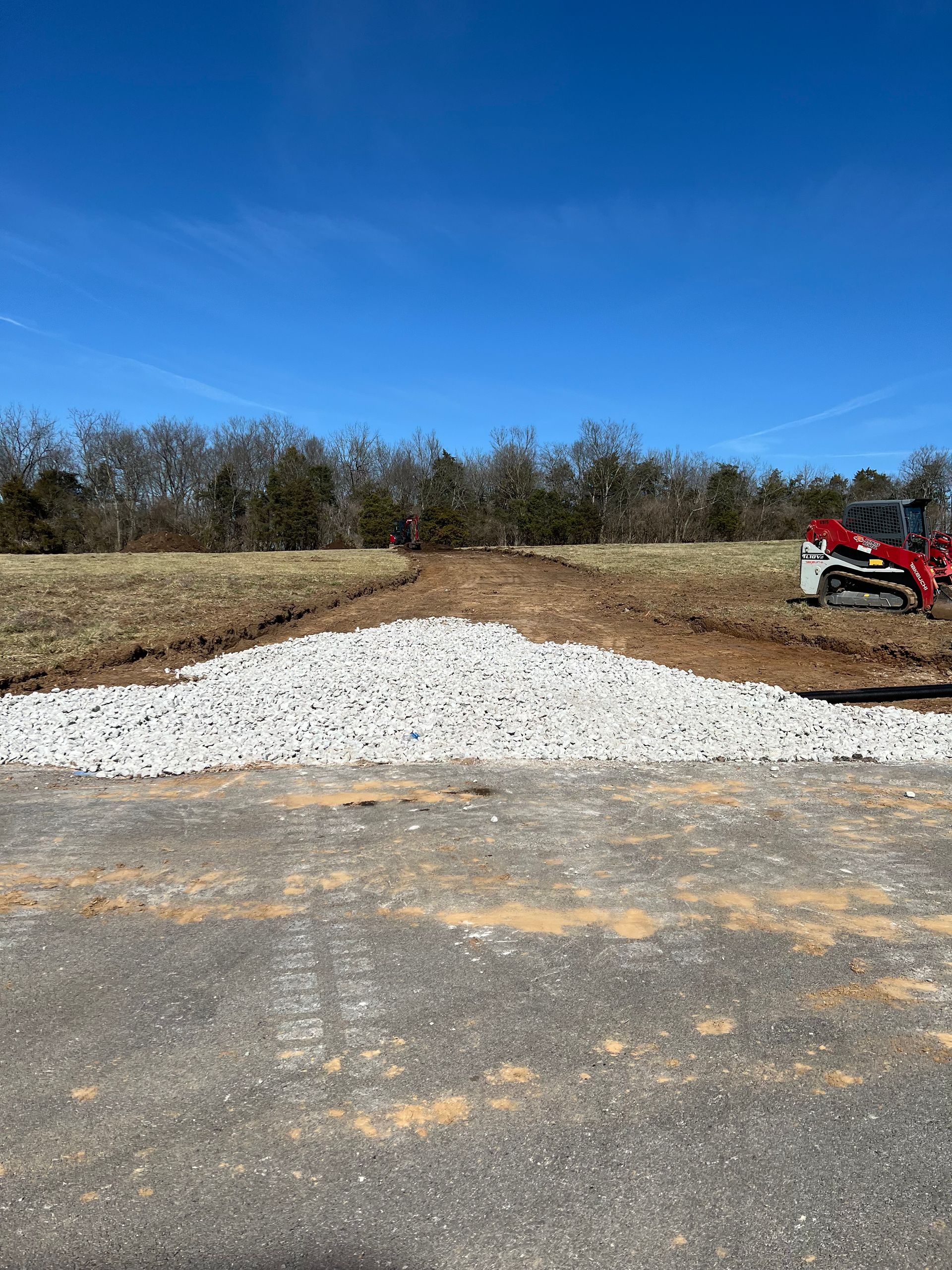 A large pile of gravel is sitting on the side of a road.