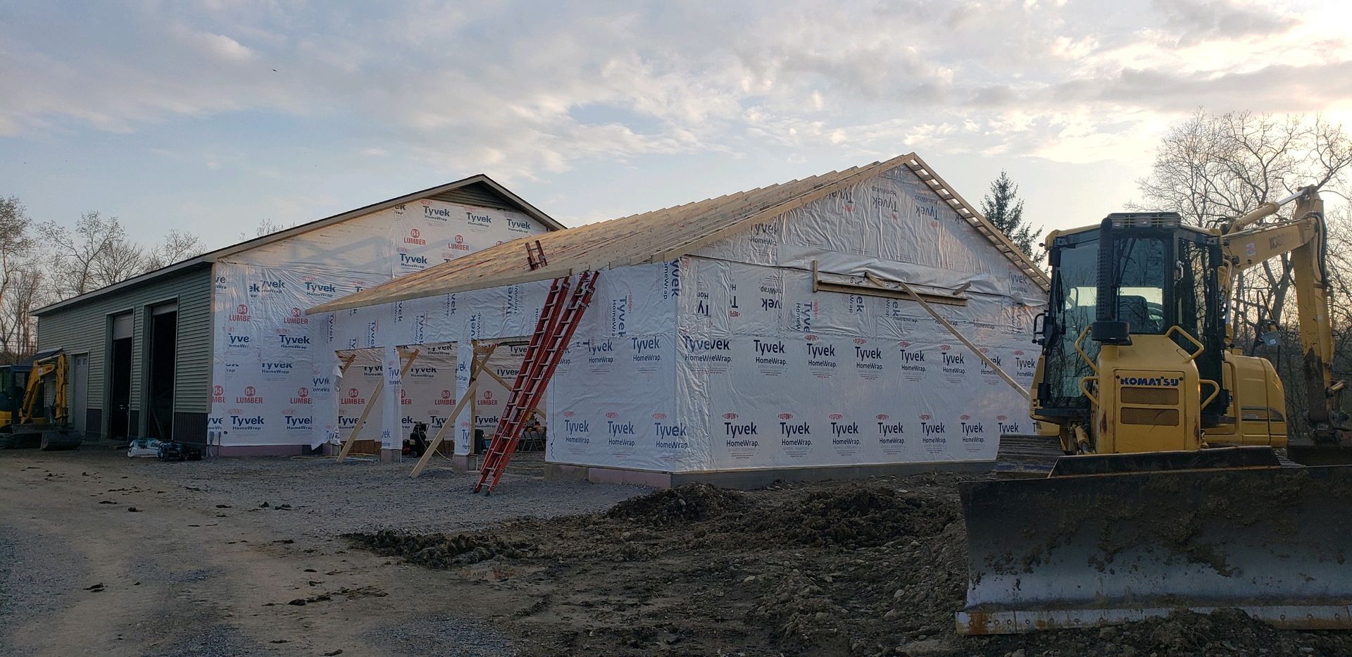 A house is being built with a bulldozer in front of it.