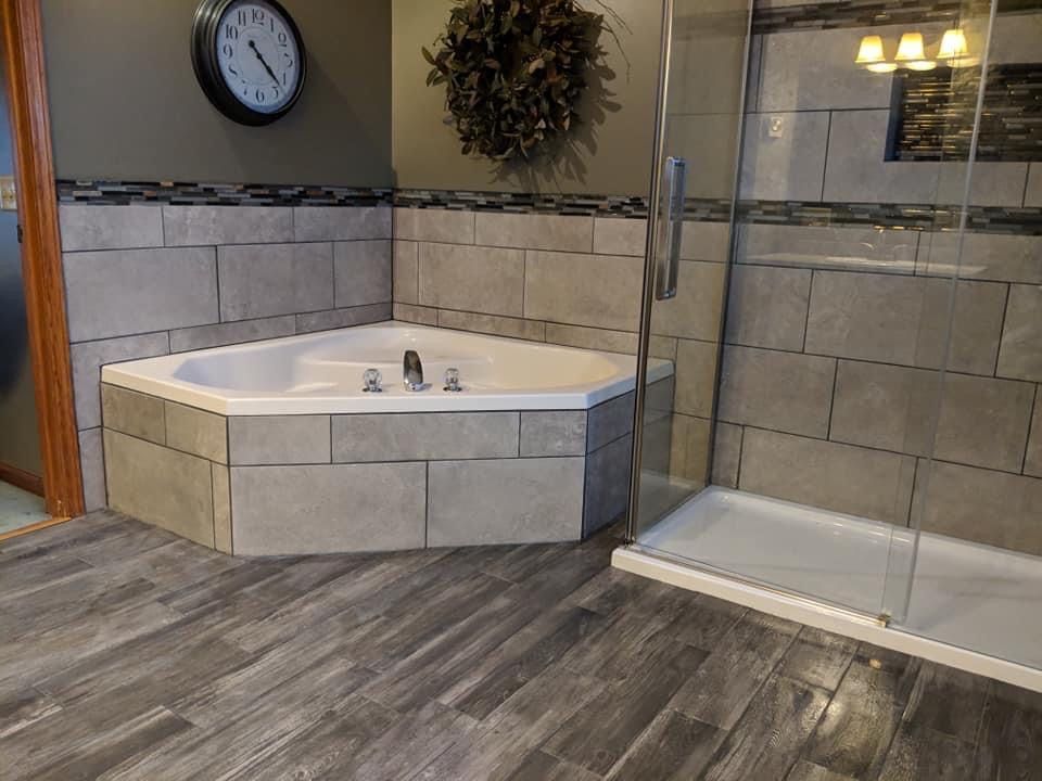 A bathroom with a jacuzzi tub and a walk in shower.