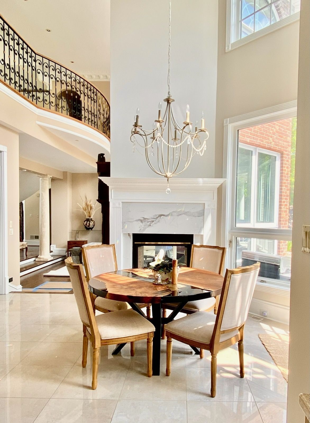 A dining room with a table and chairs and a fireplace.