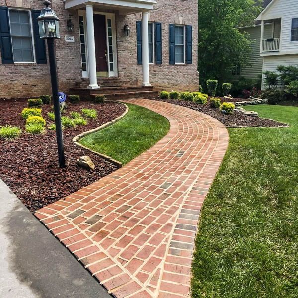 A brick walkway leading to the front door of a house