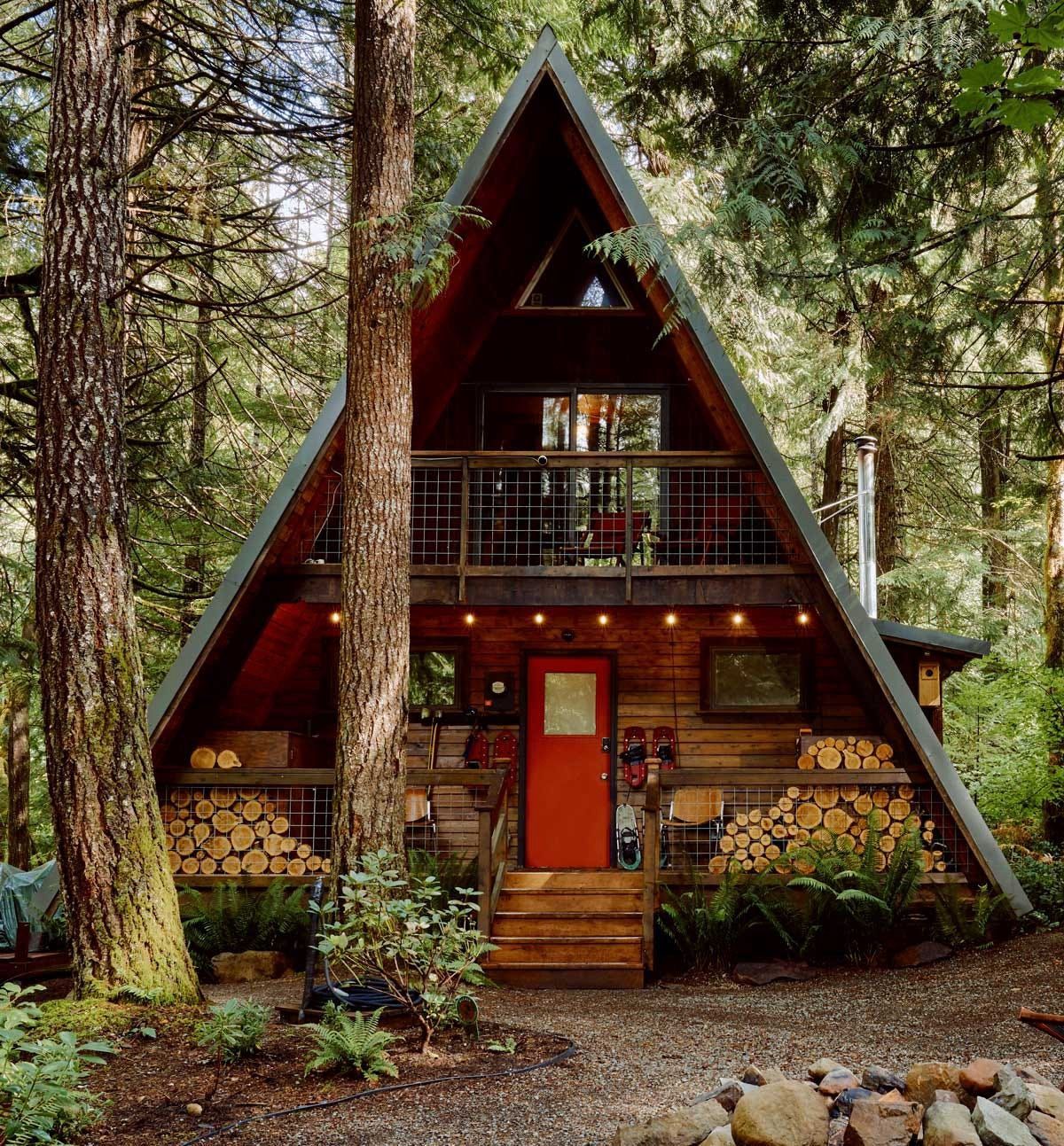 A small a frame cabin in the middle of a forest