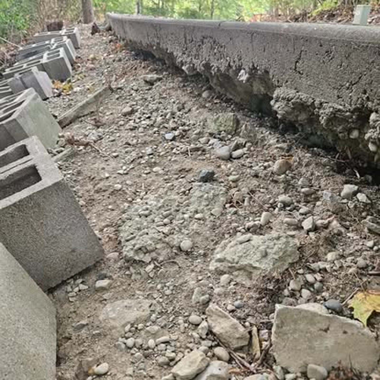 A pile of concrete blocks sitting on top of a dirt road.