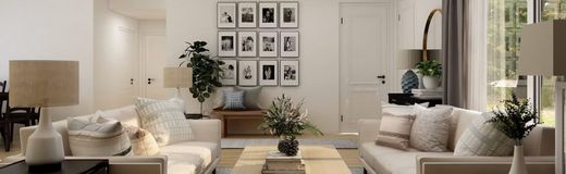 Bright neutral living room with beige sofas, houseplants, and a wall of framed photos