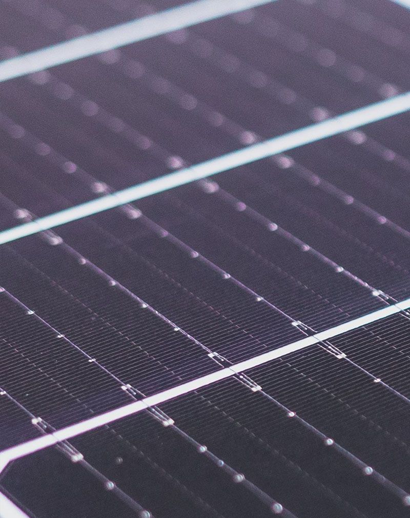 Close-up of dark solar panels with white grid lines and diagonal reflections
