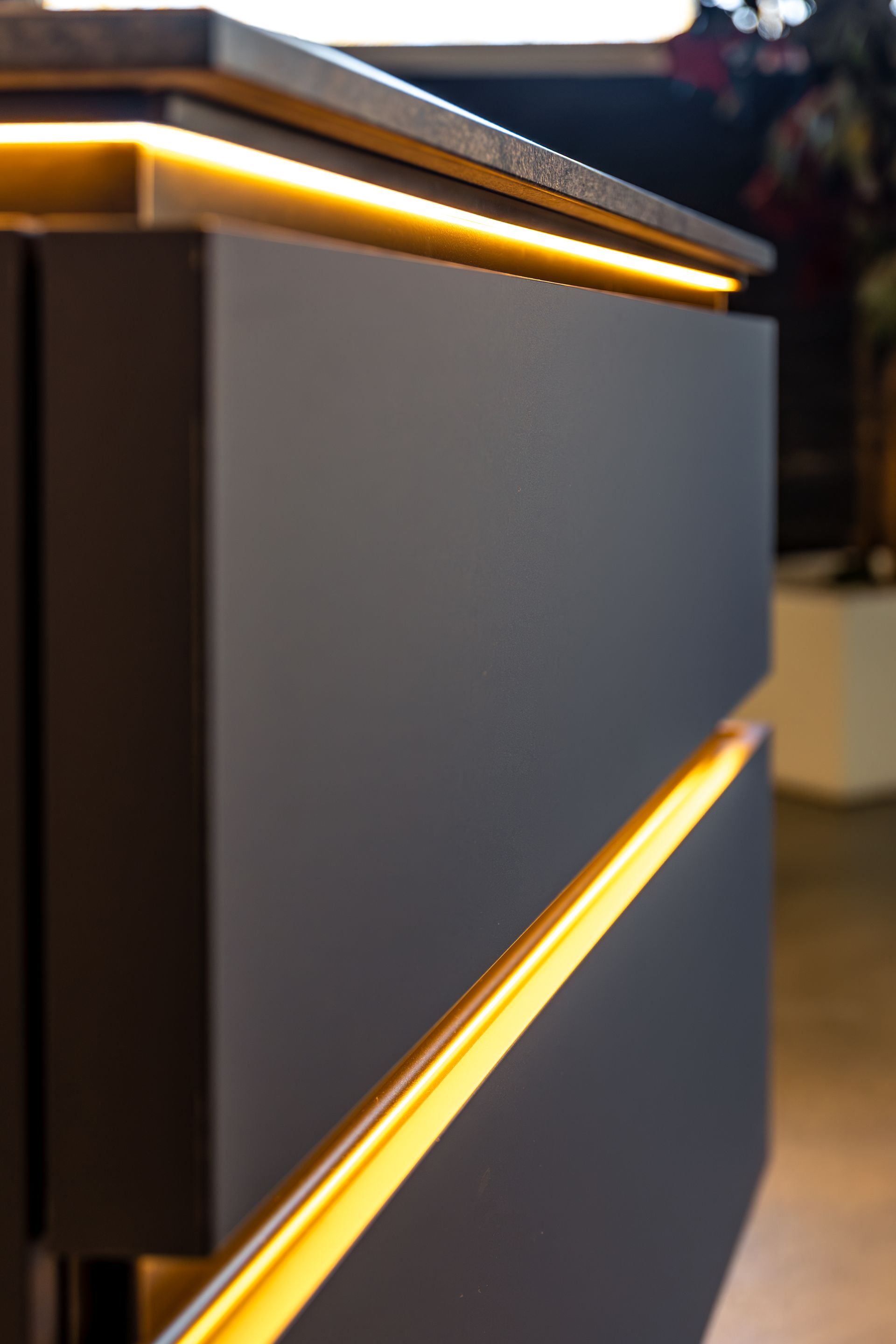Modern gray cabinet with warm LED light strips along the edges