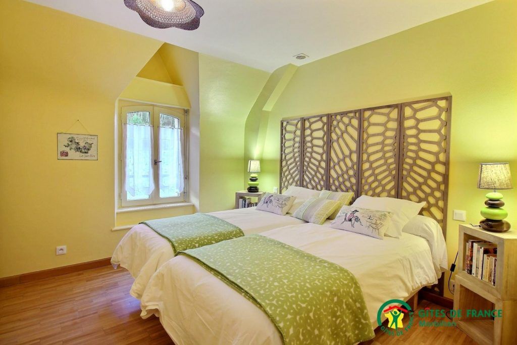 Une chambre avec deux lits et une fenêtre.