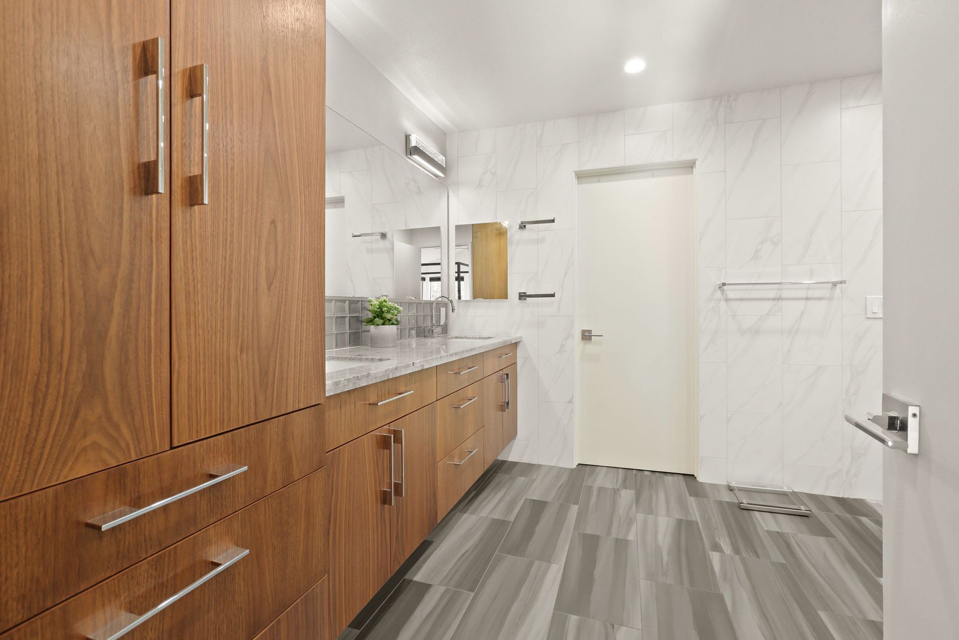 A bathroom with wooden cabinets , a sink and a mirror.