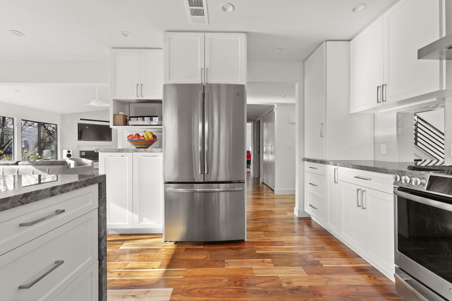 A kitchen with stainless steel appliances and white cabinets.