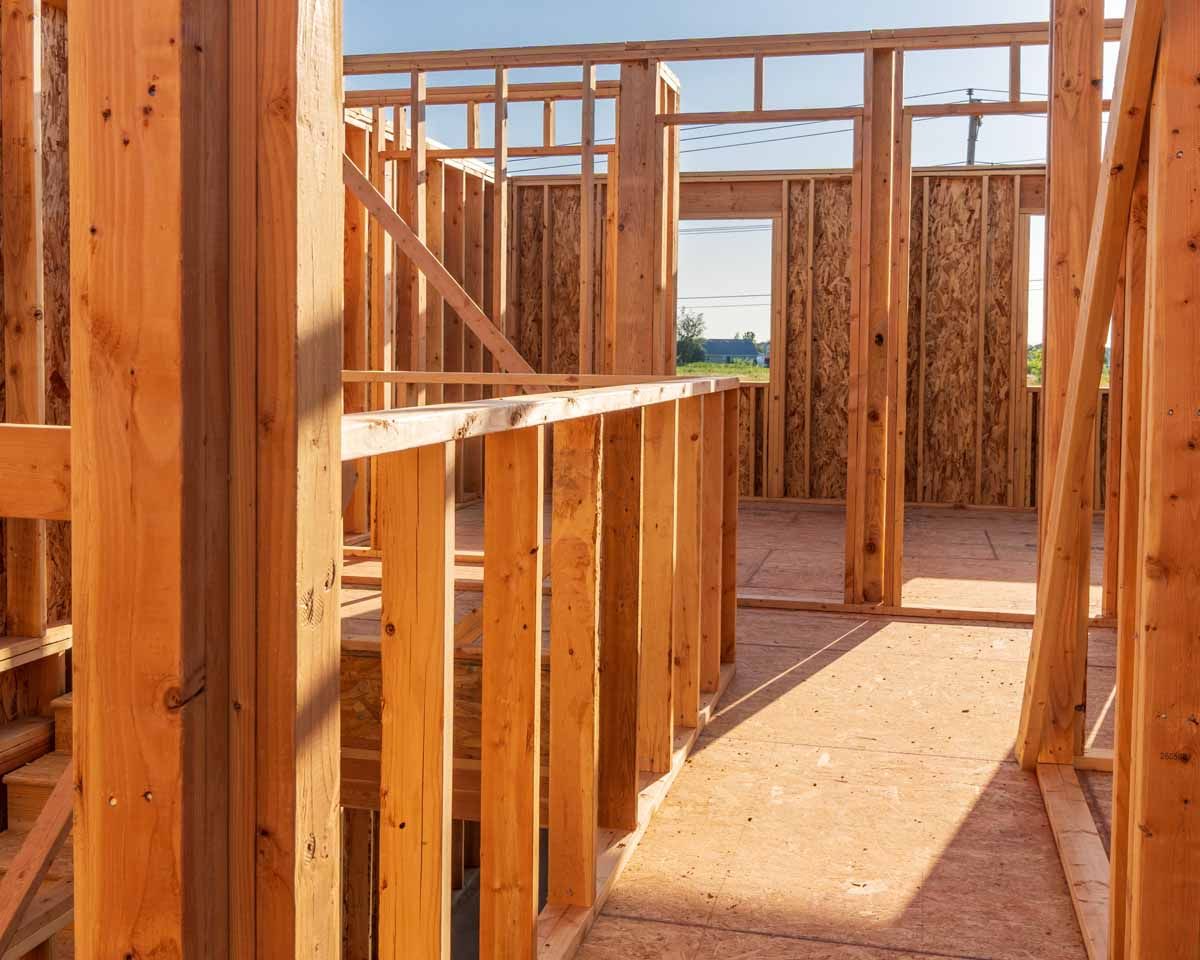 Wooden house frame construction. Interior view with sunlight, ready for walls and floors.