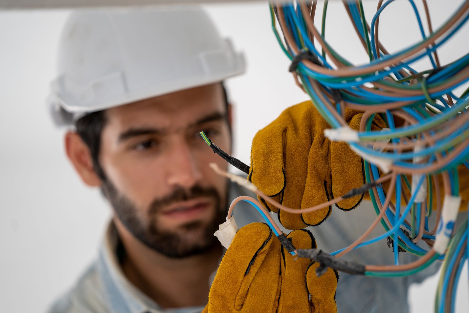 Residential electrician inspecting exposed wiring during an electrical panel upgrade.