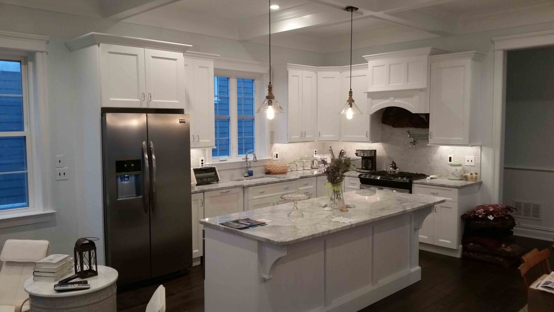 A kitchen with white cabinets , stainless steel appliances and a large island.