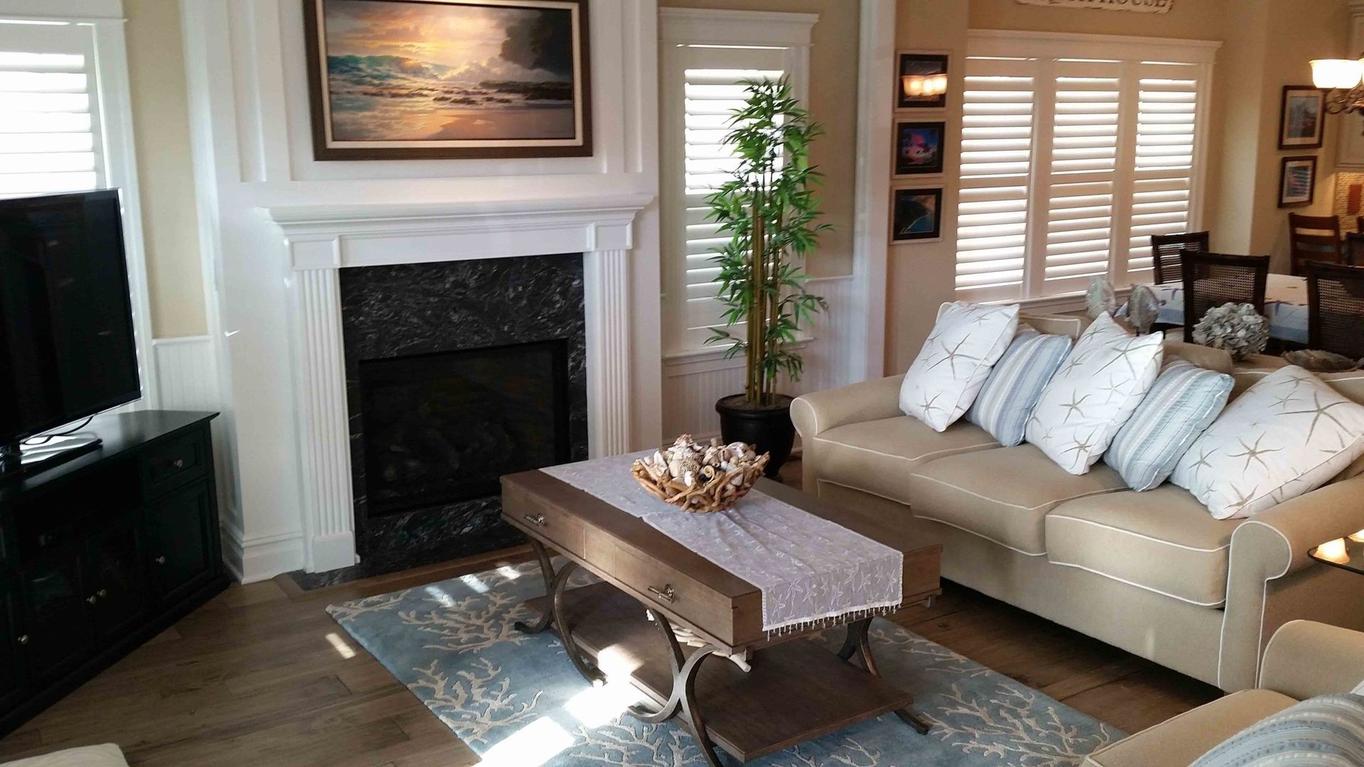 A living room with a couch , coffee table , fireplace and television.