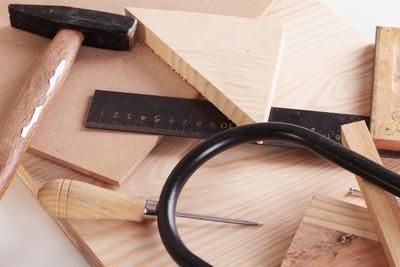 A hammer is laying on top of a pile of wood