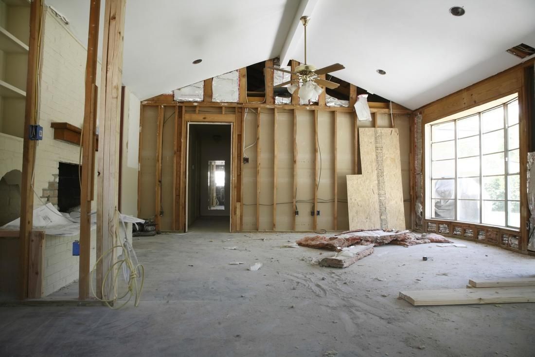 An empty room with a ceiling fan and a lot of windows