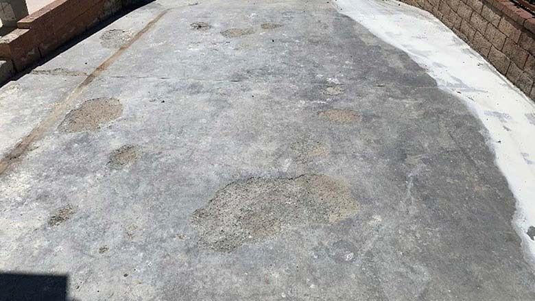 Weathered concrete walkway with patches of snow or salt along the edges