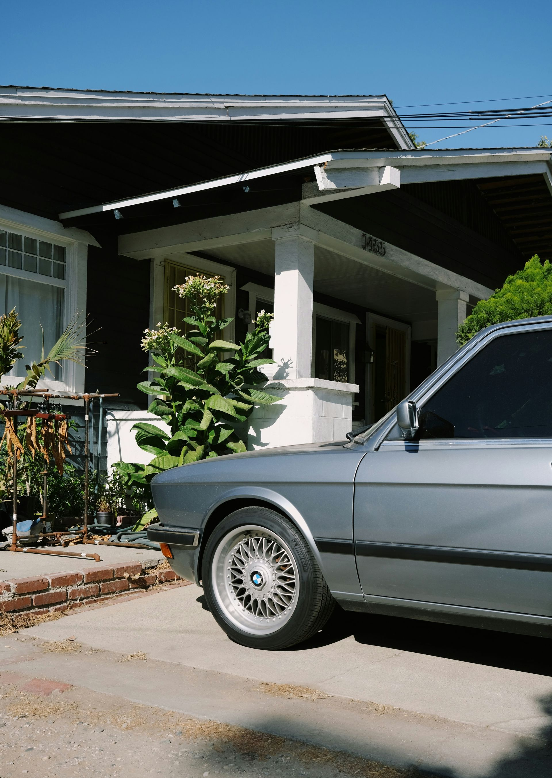 Silver BMW parked in front of a house.