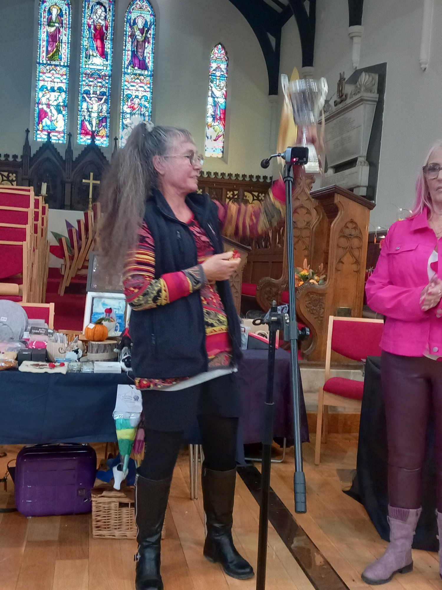 Two women are standing in a church holding a trophy