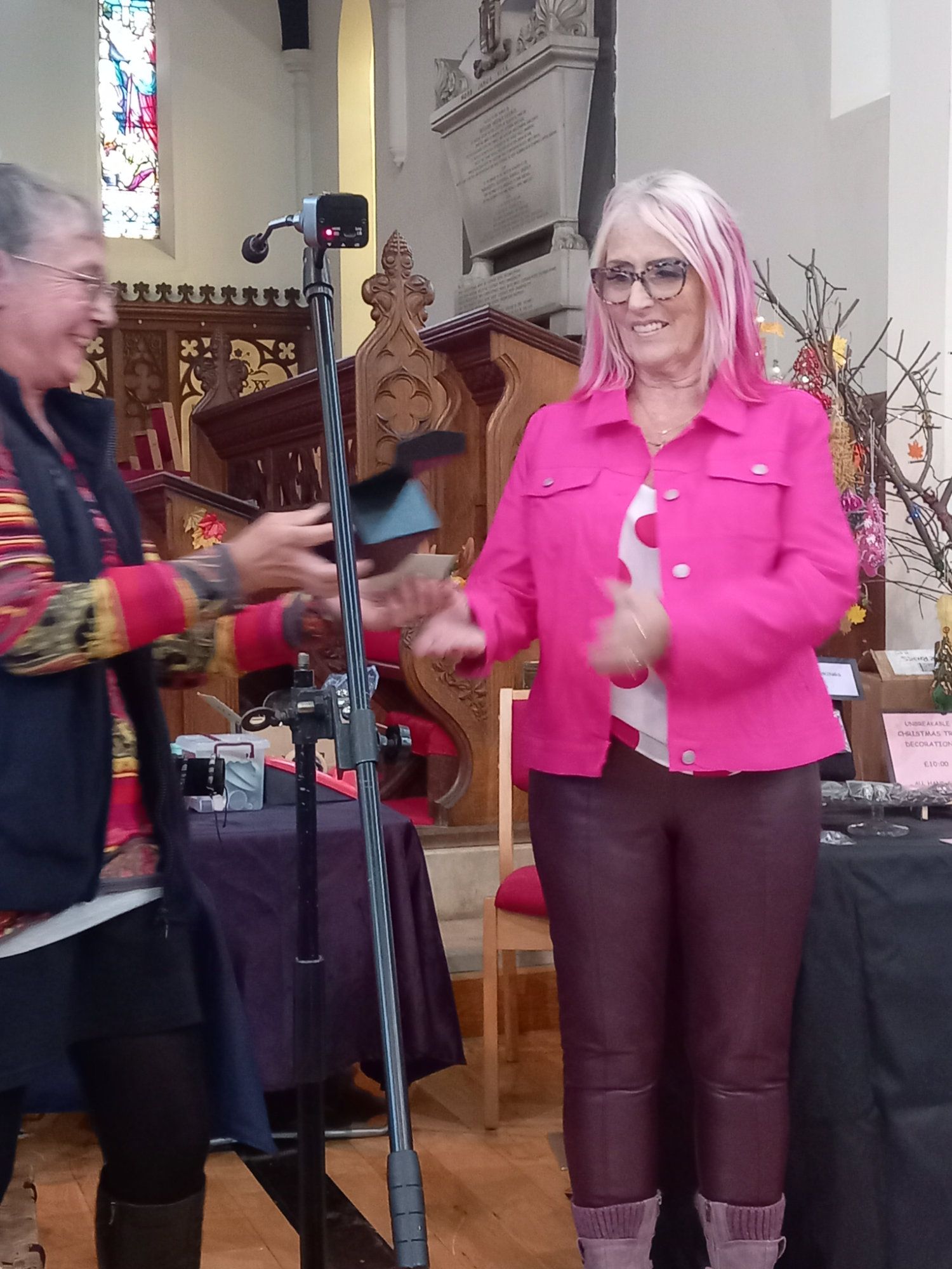 A woman in a pink jacket is standing next to another woman