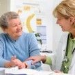 elder woman with woman doctor, doctor hand on elder woman's arm as to show comfort