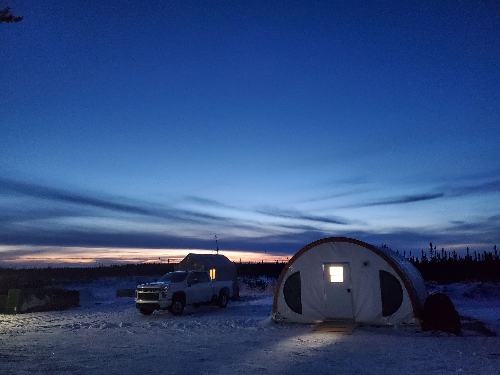 Pickup truck and tent at dusk at a Cosa Resources Saskatchewan uranium mining camp in Canada.