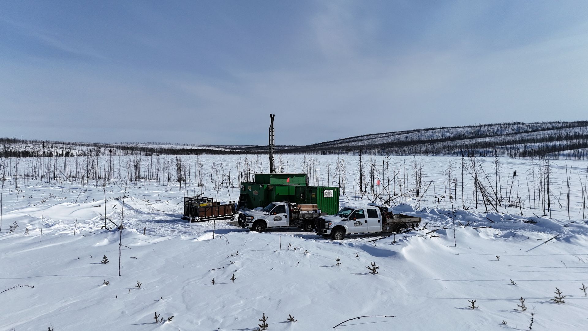 Green drill rig in a snowy field for Cosa Resources Saskatchewan uranium mining operations in Canada.