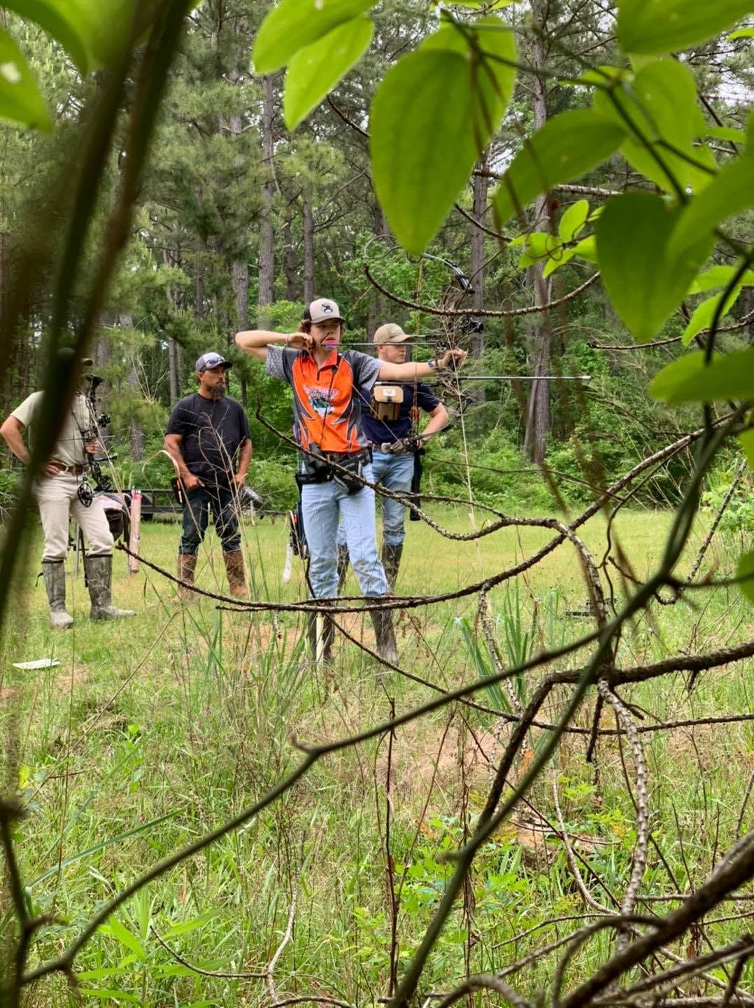 Hikers with backpacks walking through a lush green forest trail