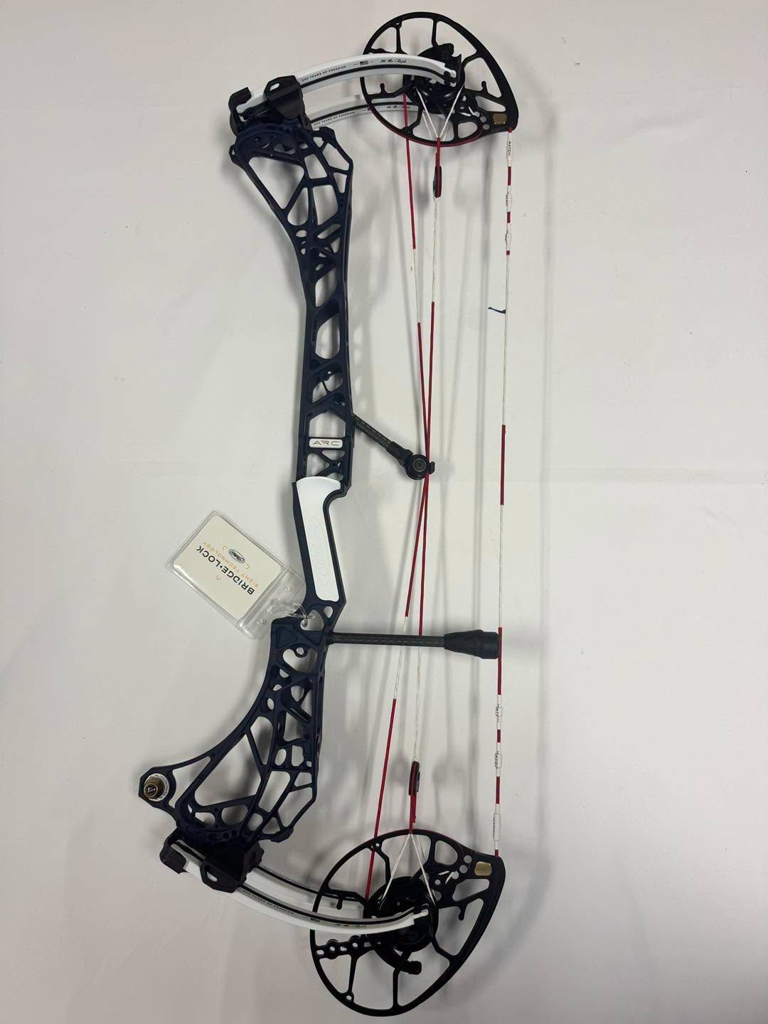 Black compound bow with red strings on a white background