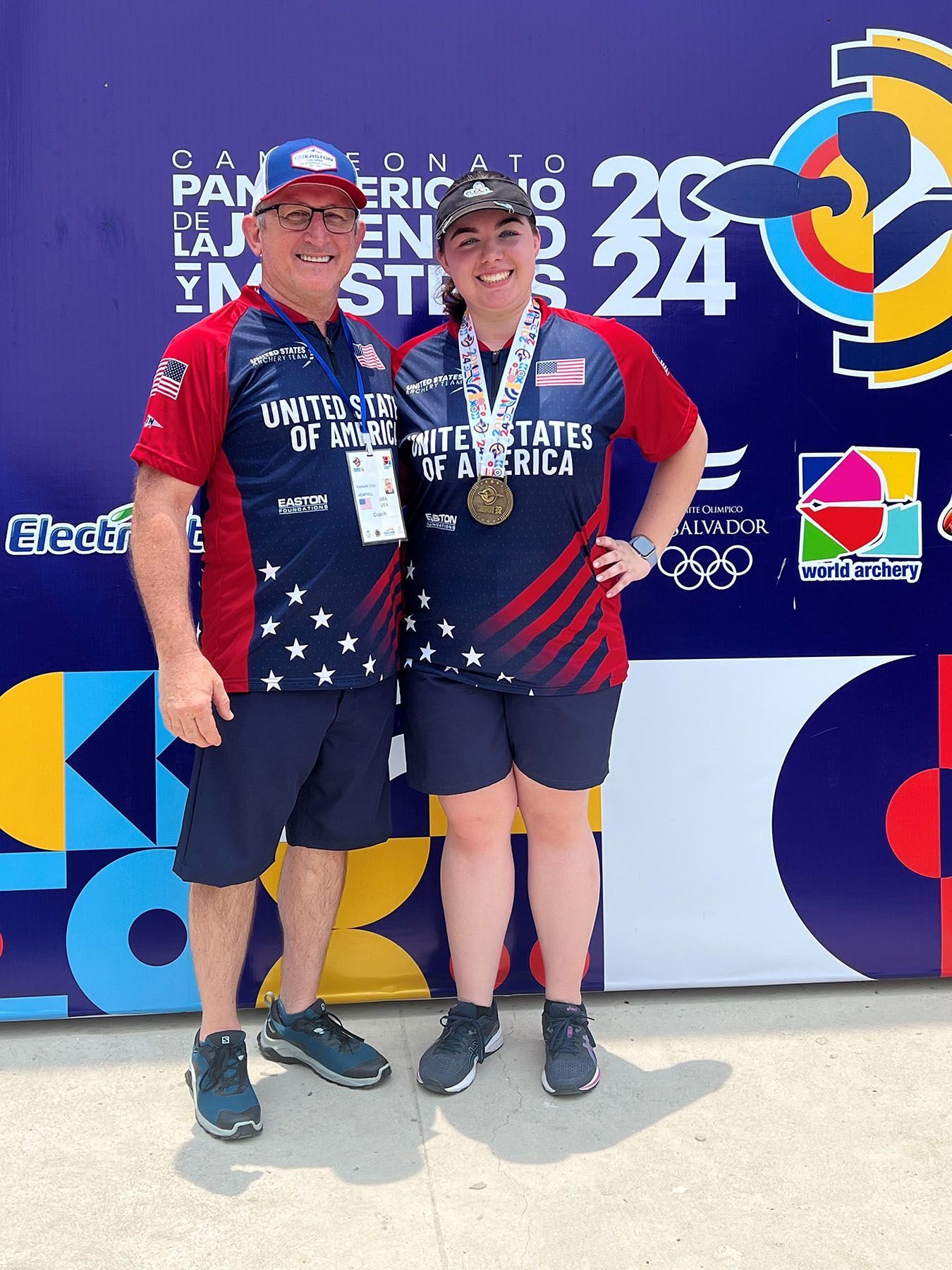 Two athletes in USA uniforms pose with medals on a podium at the Paris 2024 Olympics.