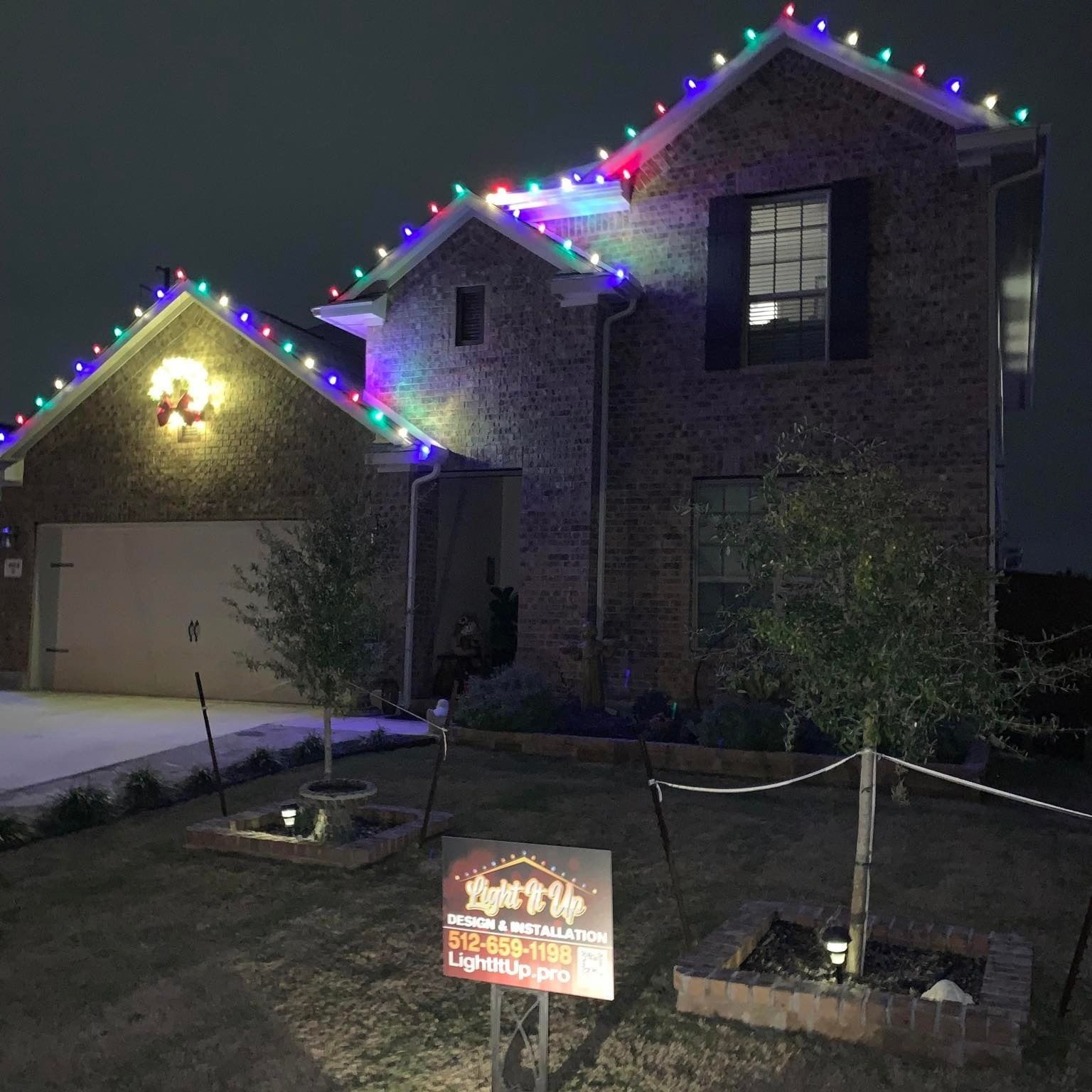 House decorated with colorful Christmas lights at night.