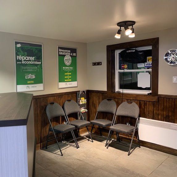 Petit espace d'attente avec quatre chaises pliantes, affiches murales, lambris et guichet de service.